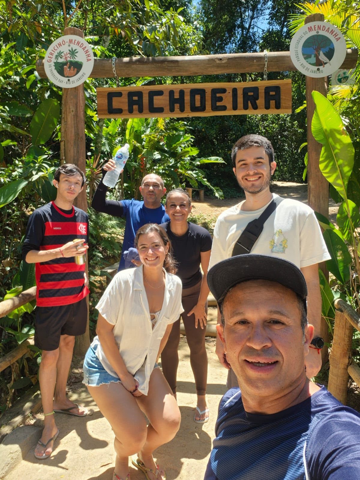 Grupo reunido na entrada de uma cachoeira